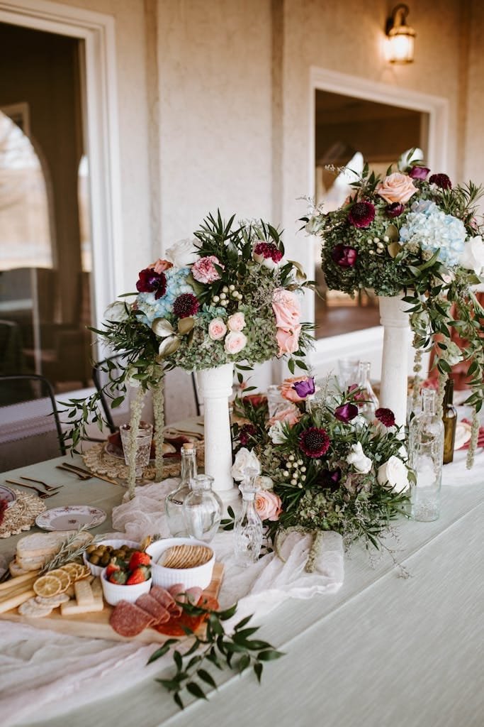 Beautiful floral arrangement on a wedding table with vintage decor and snacks in a romantic setting.